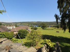 A view of houses and a lake from a garden at Haws Bank Cottage in Coniston