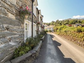 A street view with stone houses and greenery at Haws Bank Cottage in Coniston