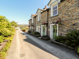 Stone cottages with greenery along the road at Haws Bank Cottage in Coniston