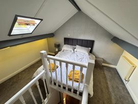 A bedroom with a bed and side table at Conway Mart Cottage in Conwy