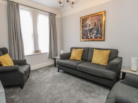 A living room with a sofa and armchair at Conway Mart Cottage in Conwy