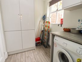 A laundry room with a washing machine and storage cabinet at Conway Mart Cottage in Conwy