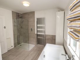 A bathroom with a shower and bathtub at Conway Mart Cottage in Conwy