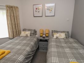 A bedroom with two beds and a bedside table at Conway Mart Cottage in Conwy