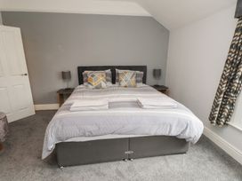 A bedroom with a bed and lamps at Conway Mart Cottage in Conwy
