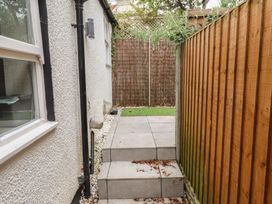 A pathway leading to grass area with wooden fence at Conway Mart Cottage in Conwy