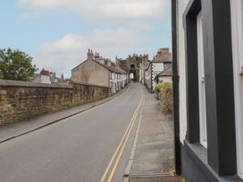 A street with buildings and a gate in the distance at Conway Mart Cottage in Conwy