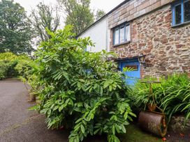 A garden with plants and a stone wall at The Water Mill at Boyton Mill Launceston