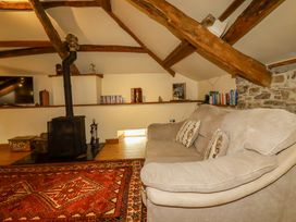 A living room with a sofa and a wood stove at The Water Mill at Boyton Mill Launceston