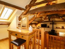 A loft area with a table and mirror at The Water Mill at Boyton Mill Launceston