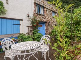 A garden with a table and chairs at The Water Mill at Boyton Mill Launceston