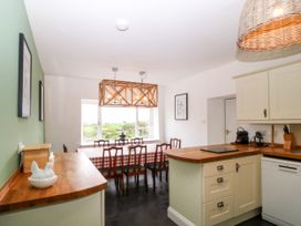 A kitchen with a dining table and chairs at Ty Mawr in Criccieth