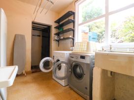 A laundry room with a washing machine and tumble dryer at Ty Mawr in Criccieth