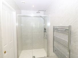 A shower area with glass enclosure and towel radiator at Ty Mawr in Criccieth