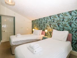 A bedroom with two single beds and a wardrobe at Ty Mawr in Criccieth