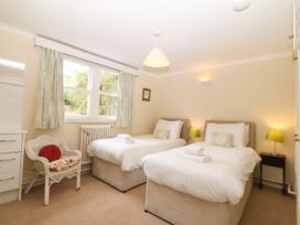 A bedroom with two beds and a chair at Ty Mawr in Criccieth
