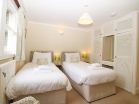 A bedroom with two beds and a closet at Ty Mawr in Criccieth