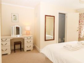A bedroom with a bed and vanity at Ty Mawr in Criccieth
