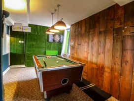 A game room with a pool table and a dartboard at Ty Mawr in Criccieth