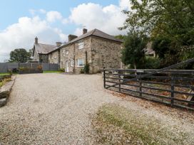 An outdoor area with a stone house and gravel driveway at Ty Mawr Criccieth