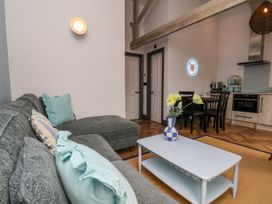 A living room with a sofa and dining area at Apartment Blue in Whitby