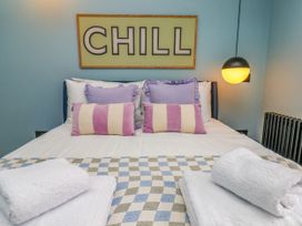 A bedroom with a bed, pillows, towels, and a light fixture at Apartment Blue in Whitby