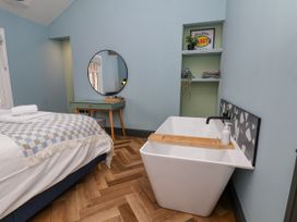 A bedroom with a bed and a bathtub at Apartment Blue in Whitby