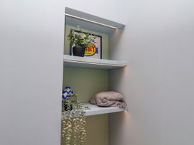 A nook with shelves containing a plant, picture, vase, and blanket at Apartment Blue in Whitby