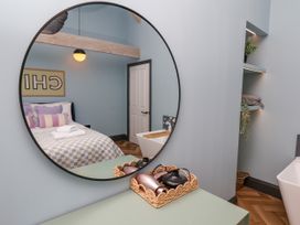 A bedroom with a bed and mirror at Apartment Blue in Whitby