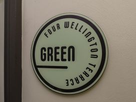 A sign displaying Four Wellington Terrace Green