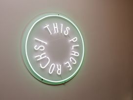 A neon sign saying 'THIS PLACE ROCKS'