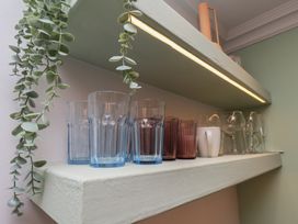 A shelf with various glasses in a kitchen at Apartment Green in Whitby