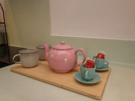 A tea set with a pink teapot and cups on a tray at Apartment Green in Whitby