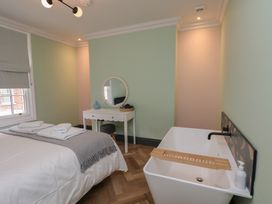 A bedroom with a bed and bathtub at Apartment Green in Whitby