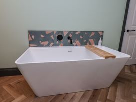 A bathtub with a wooden tray at Apartment Green in Whitby
