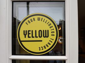 A yellow sign stating FOUR WELLINGTON TERRACE at Apartment Yellow in Whitby