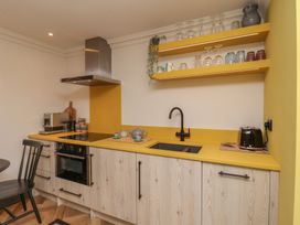 A kitchen with yellow countertop and shelves at Apartment Yellow in Whitby