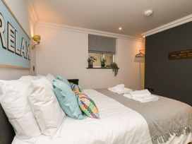 A bedroom with a bed and decorative cushions at Apartment Yellow in Whitby
