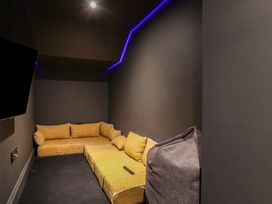 A snug with yellow couch and television at Apartment Yellow in Whitby