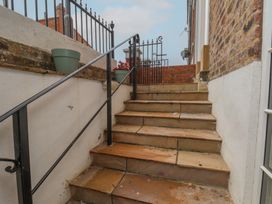Stairs leading up with a handrail and planters at Apartment Yellow in Whitby