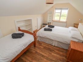 A bedroom with two beds and a dresser at Islands Inn in Louisburgh, County Mayo