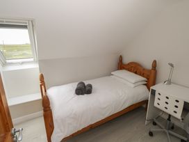 A bedroom with a bed and desk at Islands Inn in Louisburgh, County Mayo