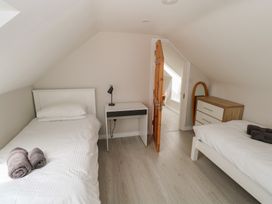 A bedroom with two beds and a desk at Islands Inn, Louisburgh, County Mayo
