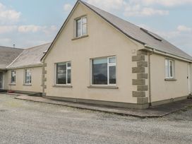 A house with multiple windows and a gravel area at Islands Inn in Louisburgh, County Mayo