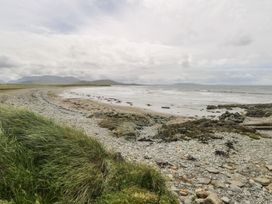 A beach with rocks and grass at Islands Inn, Louisburgh, County Mayo