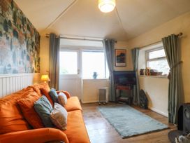 A living room with a sofa and television at Bwthyn Bach in Pentrefelin