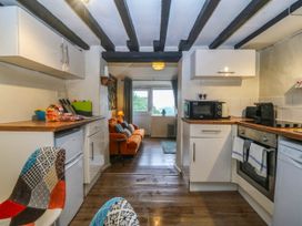 A kitchen with appliances and seating area at Bwthyn Bach in Pentrefelin