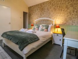 A bedroom with a bed and desk at Bwthyn Bach in Pentrefelin