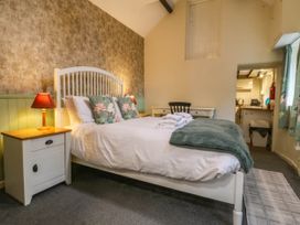 A bedroom with a bed and furniture at Bwthyn Bach in Pentrefelin