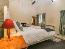 A bedroom with a bed and bedside table at Bwthyn Bach in Pentrefelin